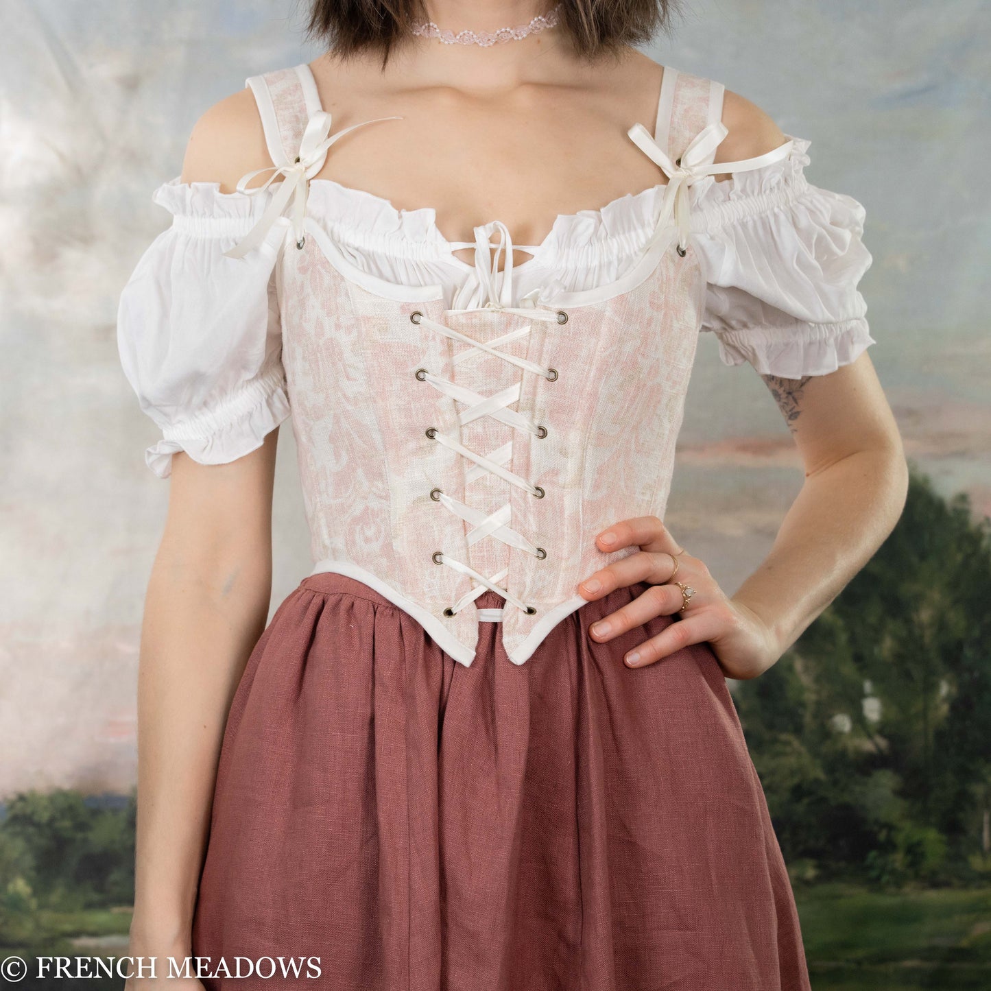 model wearing a pink renaissance bodice and off the shoulder blouse in a tavern wench style