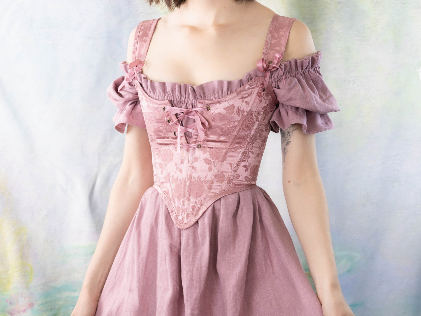 Woman wearing a pink off-shoulder dress with Handmade Pink Floral Satin Sarah Sanderson Stays corset lace-up front