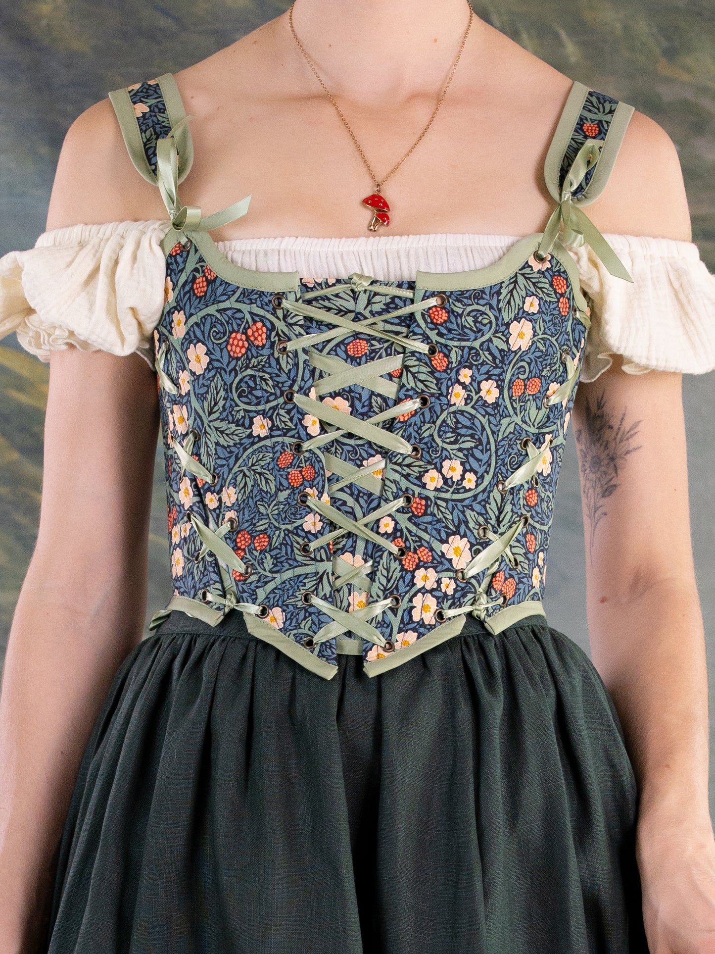 Raspberry Vines Princess Stays corset with floral pattern, green lace-up design, and adjustable shoulder straps on model