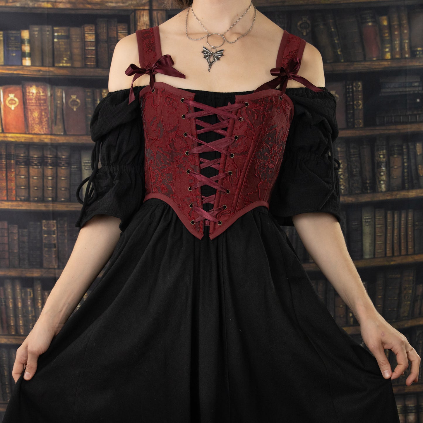 Black Cotton Puff Sleeve Chemise with red corset top, off-shoulder design and adjustable sleeve ties in library setting