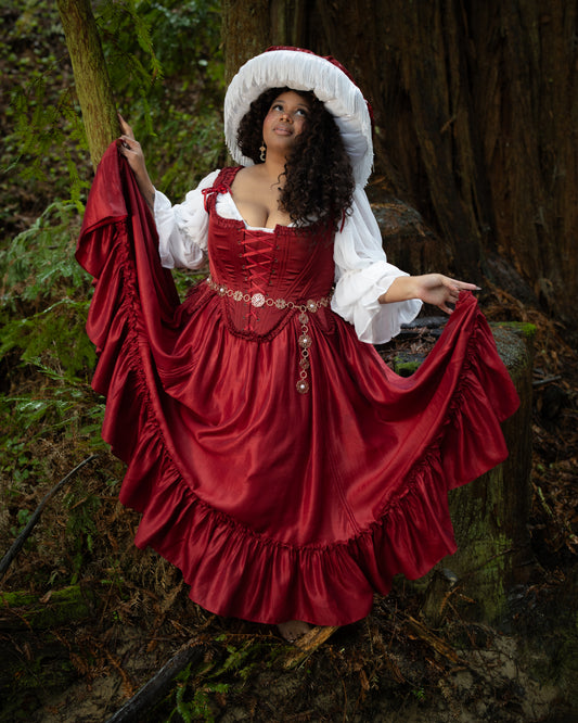 Dark Red Ruffle Skirt worn in outdoor forest setting with model holding skirt edges, portrait orientation gallery image one.