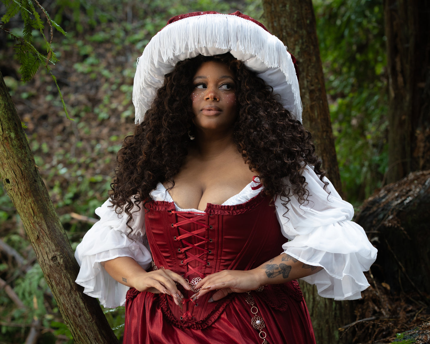 Model outdoors wearing Red Satin 18th Century Stays with ruffle trims and lace-up front, gallery position 3, landscape view