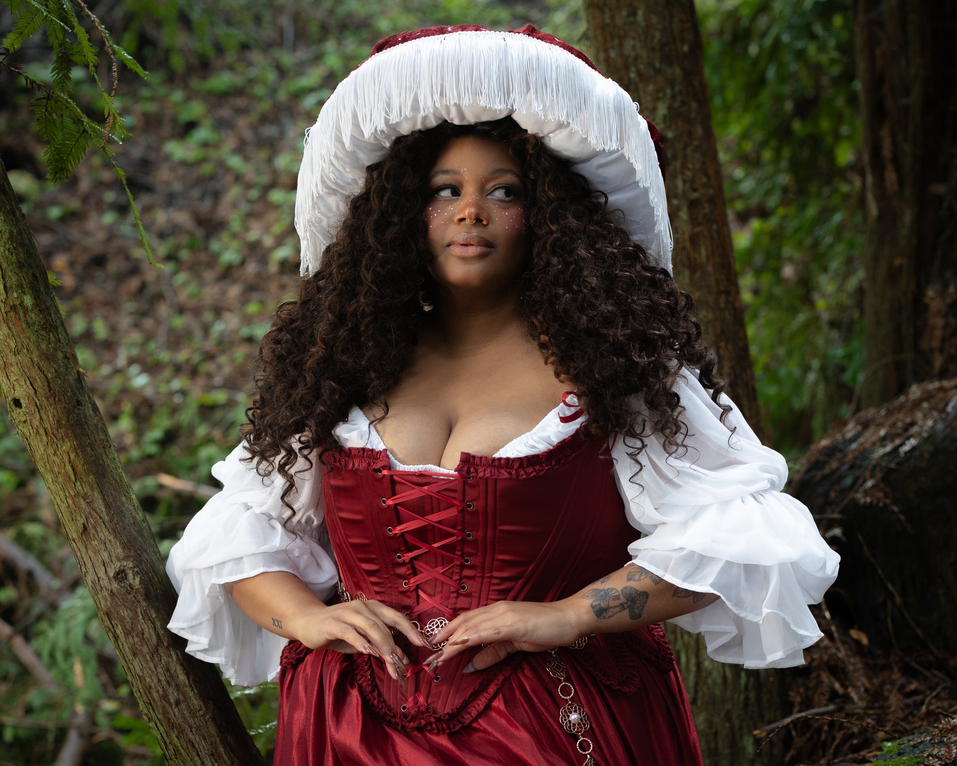 Model outdoors wearing Red Satin 18th Century Stays with ruffle trims and lace-up front, gallery position 3, landscape view