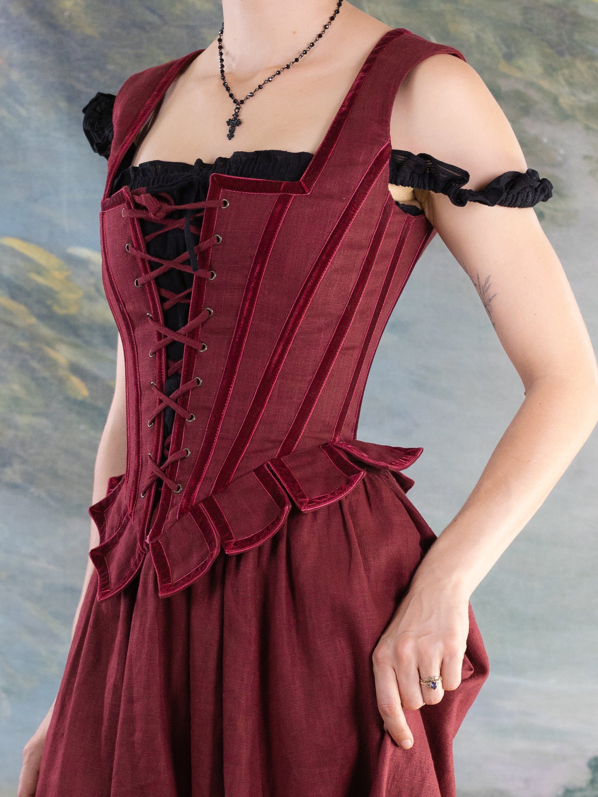 Close-up of a woman wearing a structured Red Pirate Doublet with lace-up front and ruffled waist detail.
