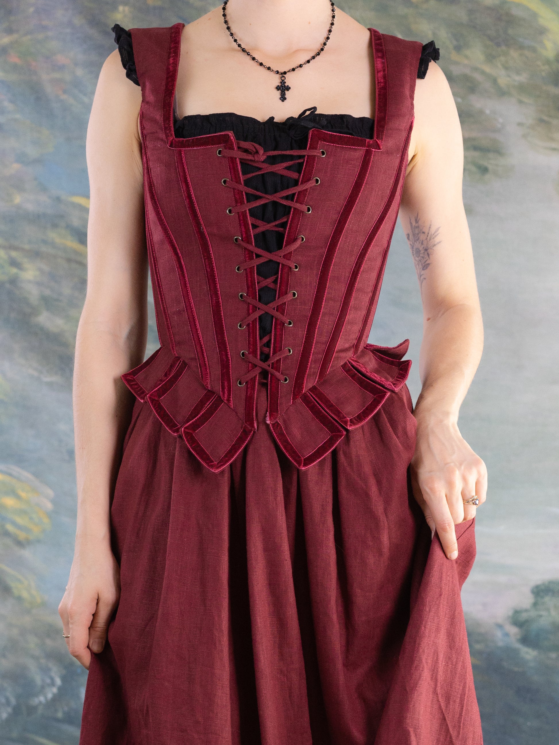 Close-up of a person wearing a red corset-style Red Pirate Doublet with ruffled detailing and black underdress.