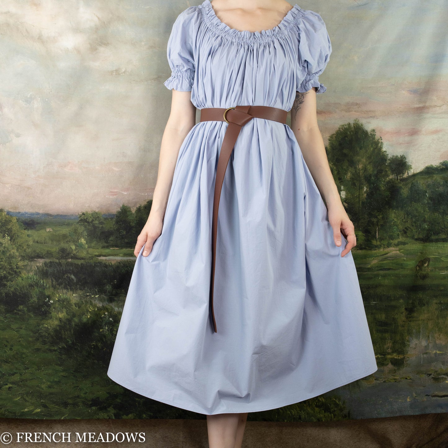 model wearing light blue cotton dress with leather belt