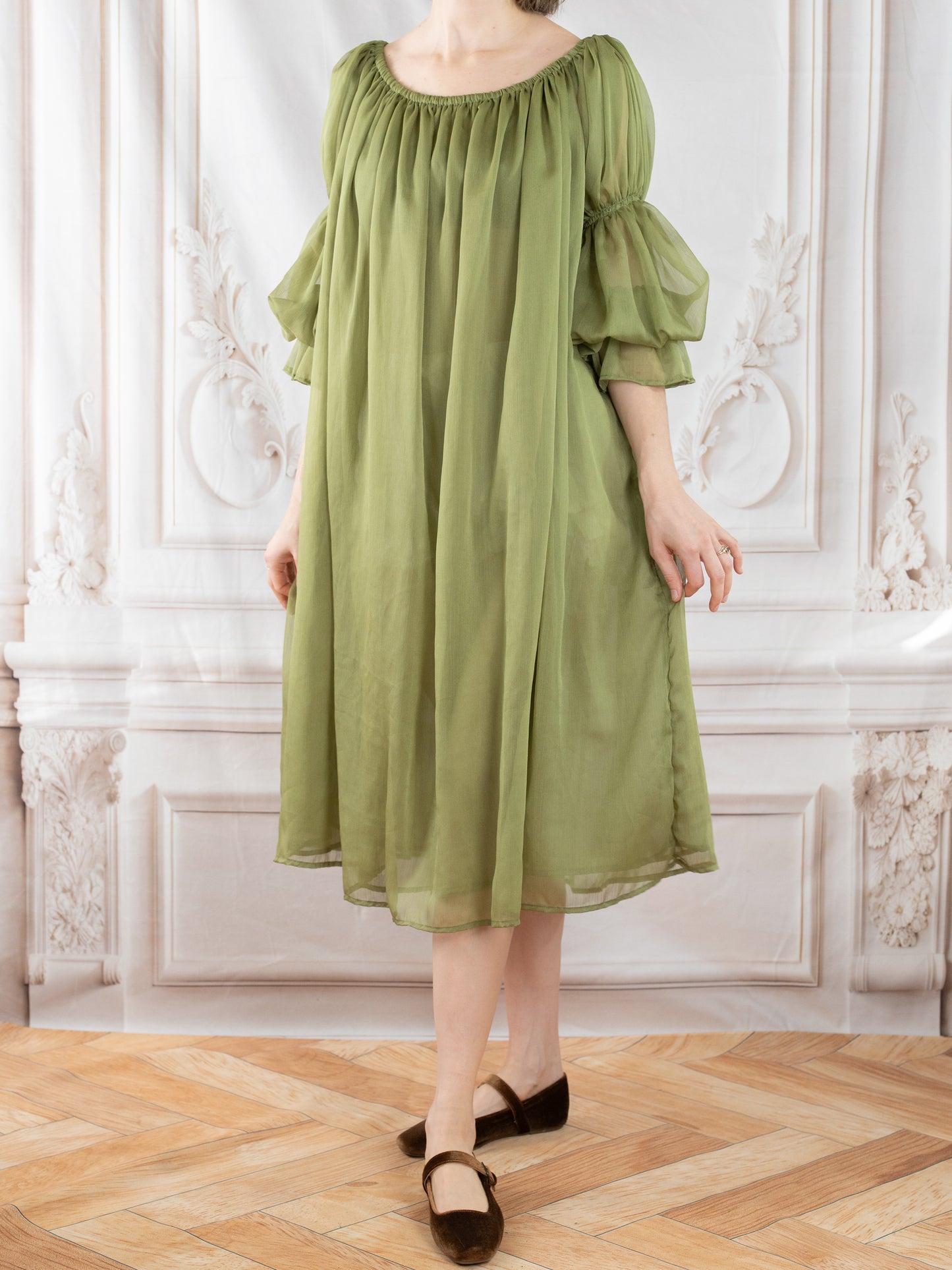 Model wearing flowing Sage Chiffon Chemise with gathered neckline and sheer puff sleeves in soft woodland green tone