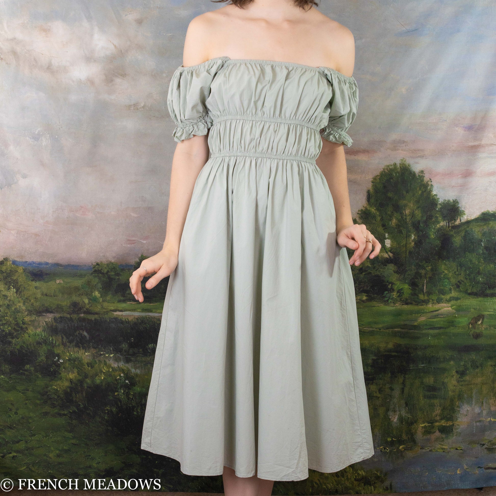 modeling wearing light green cotton dress off her shoulders