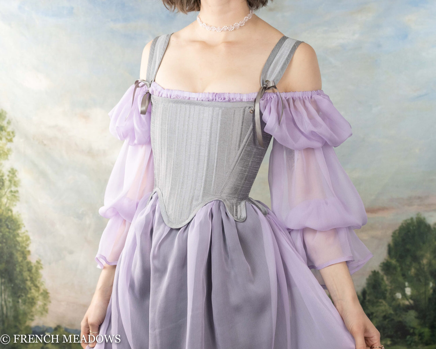 model wearing a silver set of tudor stays over a sheer lavender dress