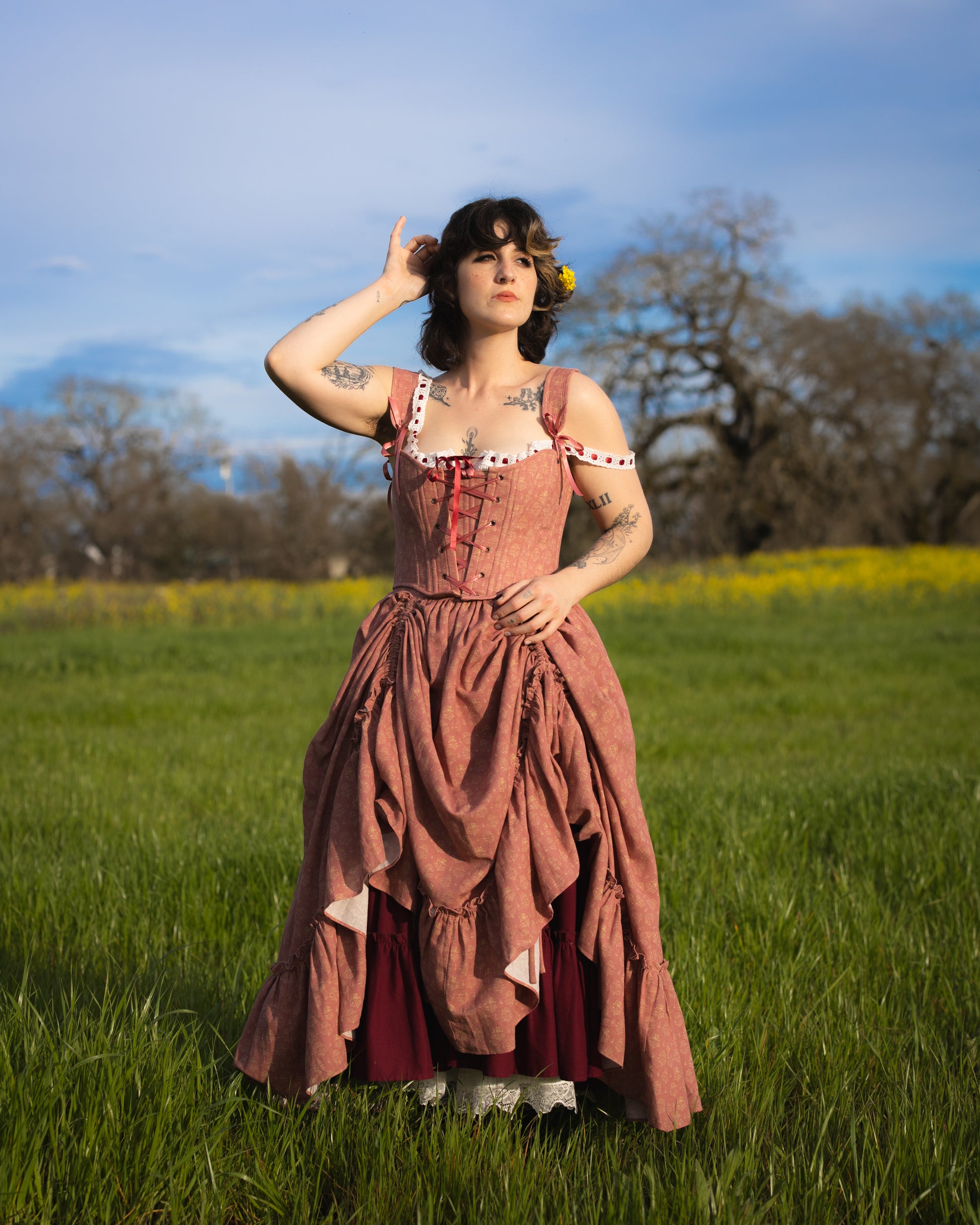 Woman standing in a field wearing a vintage-inspired Strawberry Floral Ruffle Skirt with layered ruffles and lace details
