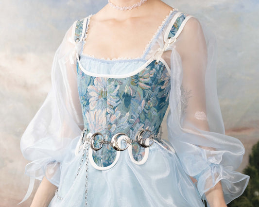 Handmade Teal Floral Tapestry 18th Century Stays worn with sheer puff sleeves and decorative silver belt details.