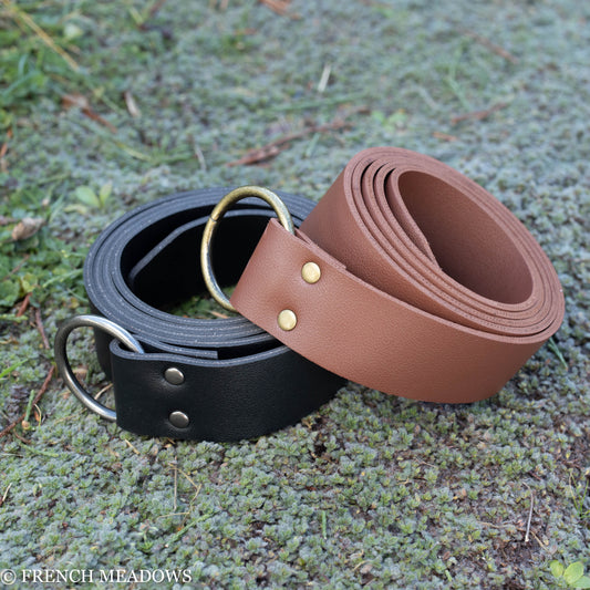 Vegan Leather Renaissance Belt in brown and black with metal D-rings and rivets, displayed on mossy ground