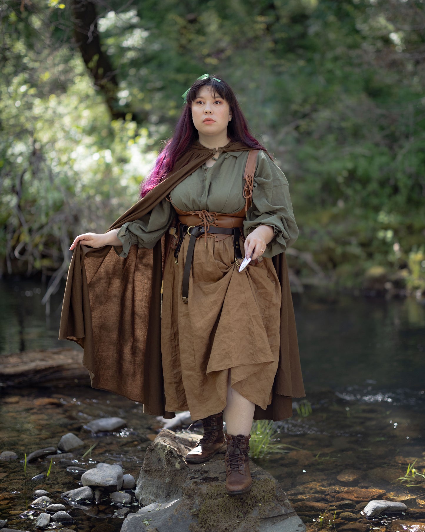 Leather Underbust Corset Belt worn over a green blouse and brown Renaissance-inspired skirt by a creek.