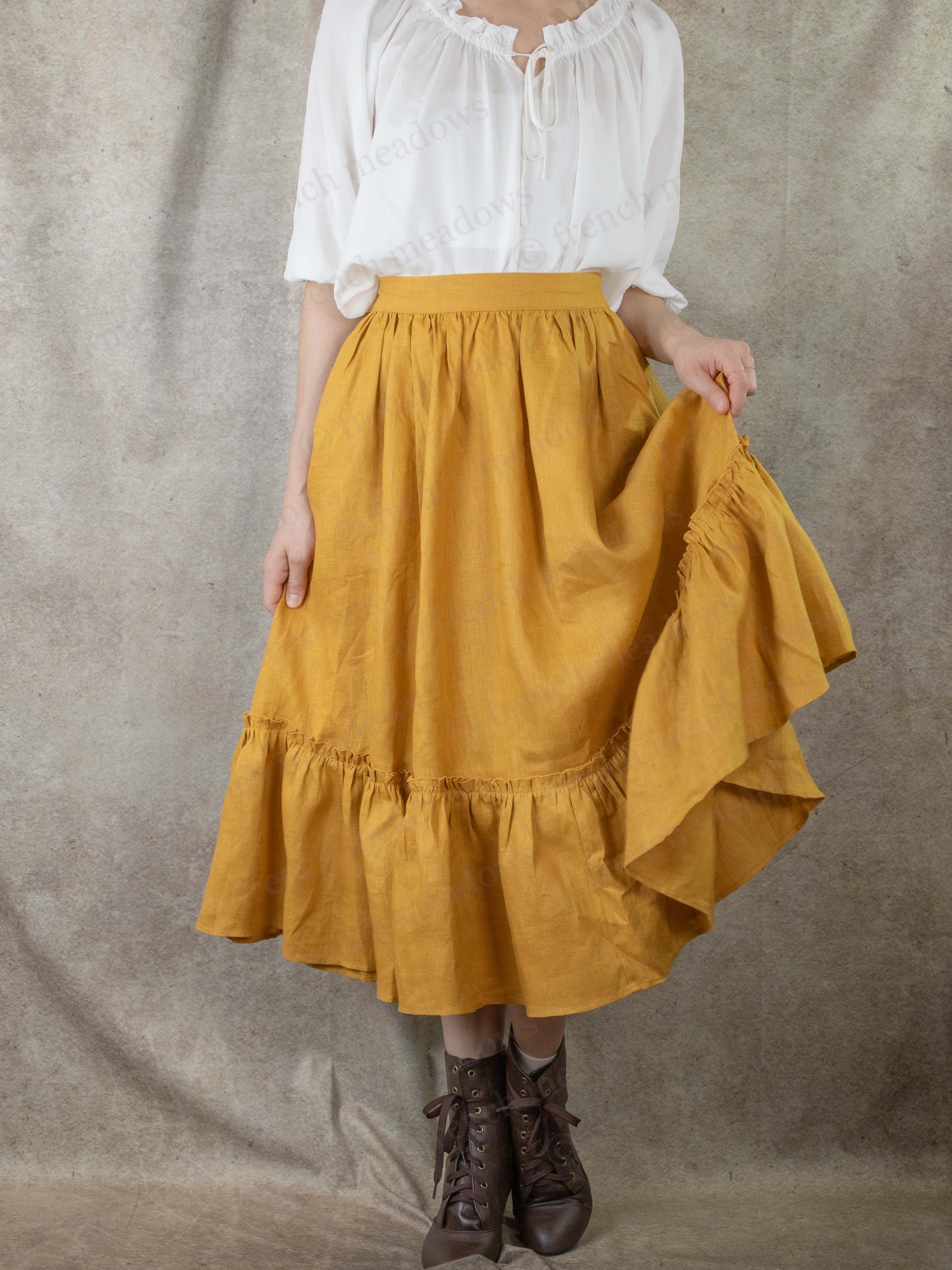 model picking up skirt hem to show ruffle hem fullness of midi skirt